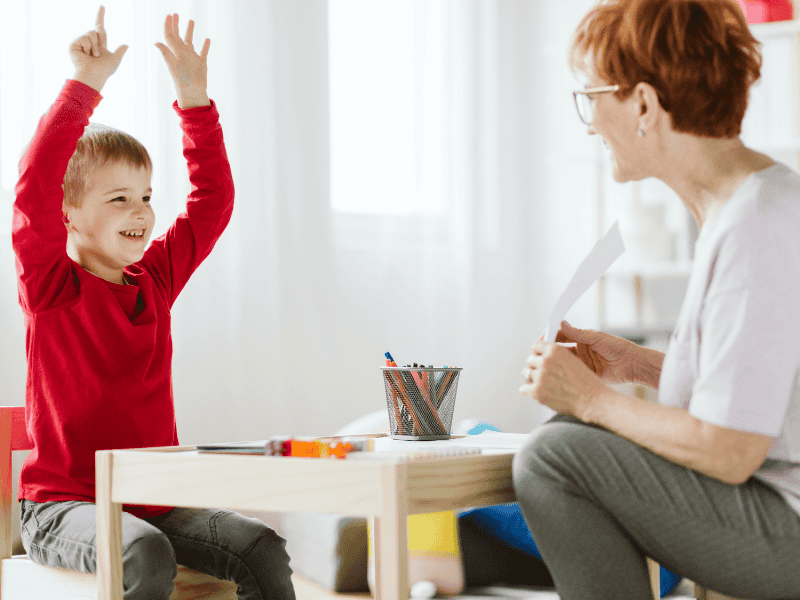 An educator assists a student in a classroom setting.